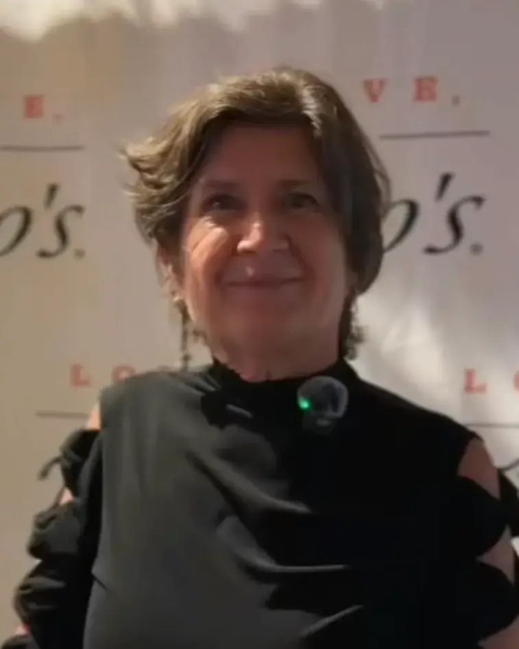A smiling woman with short brown hair, in a black top